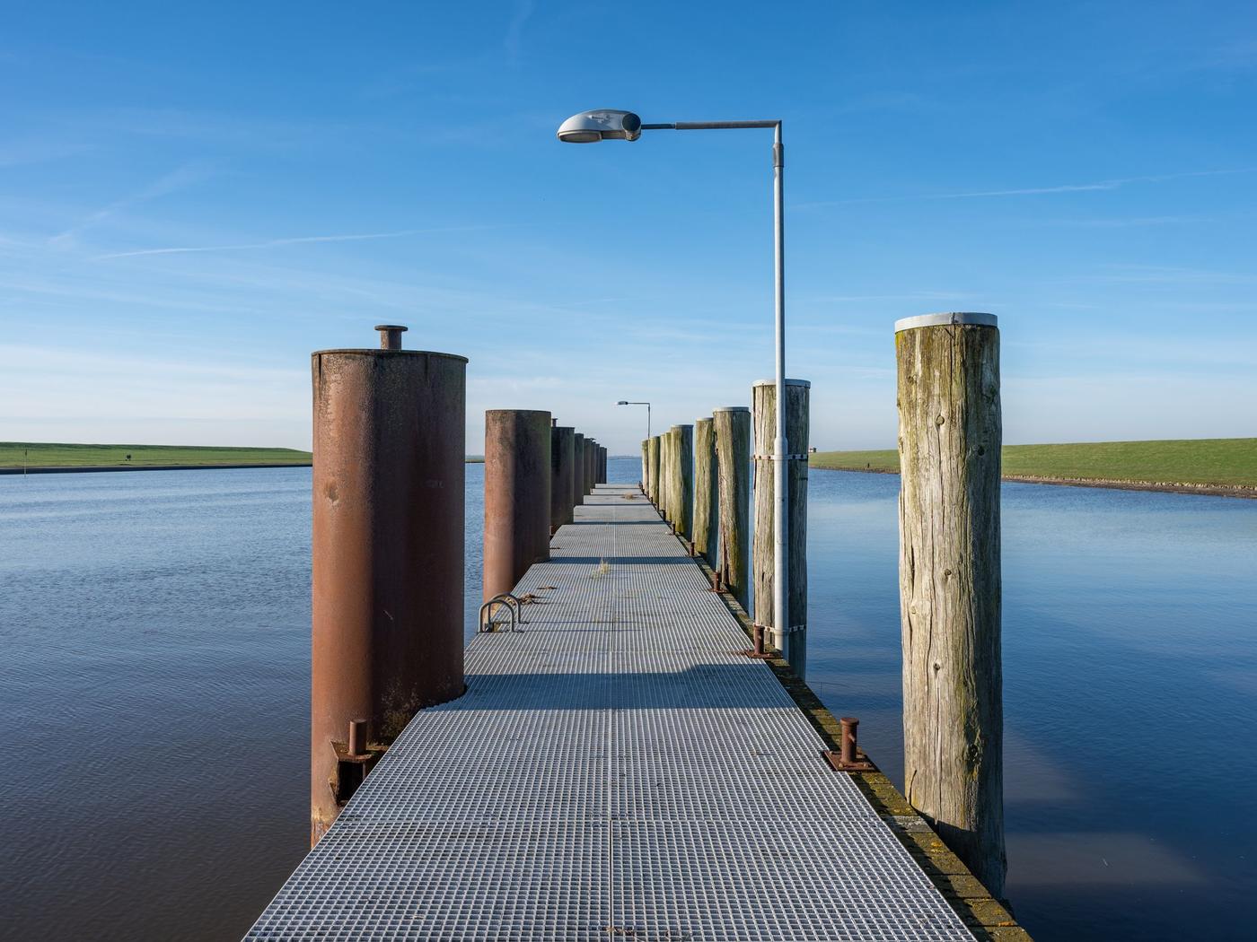 Licensed stock photograph: steel and timber pilings standing in open water.
